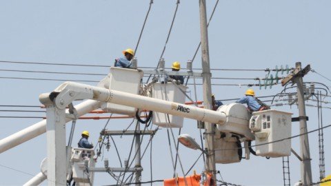 trabajadores instalando aisladores en postes de media tension