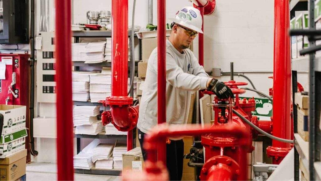 trabajador ajustando bomba de sistema contra incendio