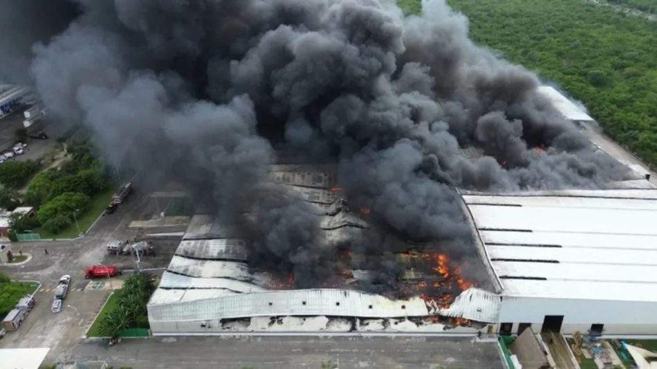 Toma aérea de bodega incendiandose