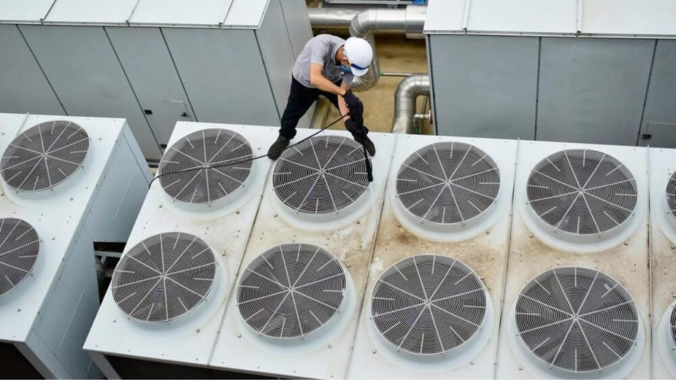 trabajador limpiando unidad rooftop